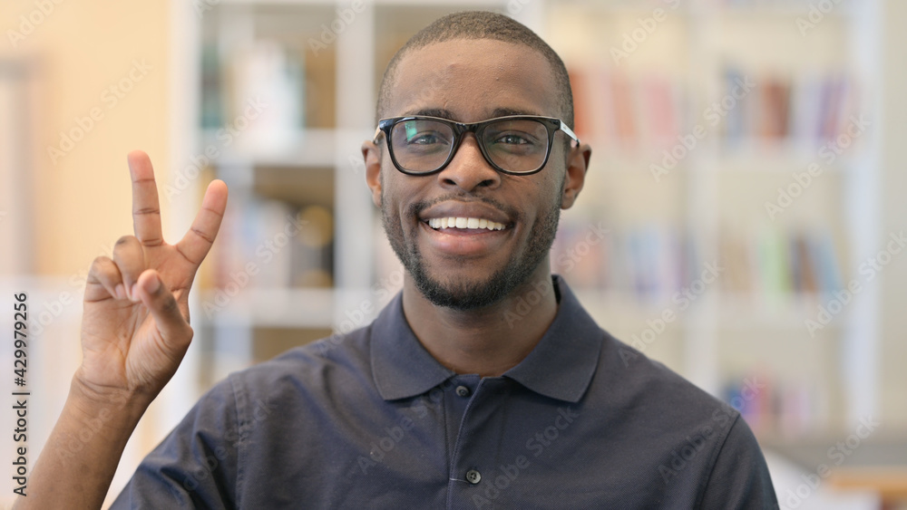 Obraz premium Portrait of Young African Man showing Victory Sign with Hand
