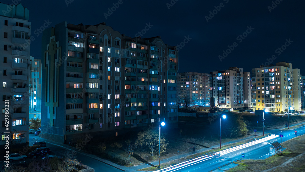  Aerial Flying low over modern town with illuminated park area between buildings views at the night 