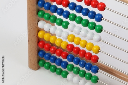 small ruler with colorful wooden balls in a white studio 