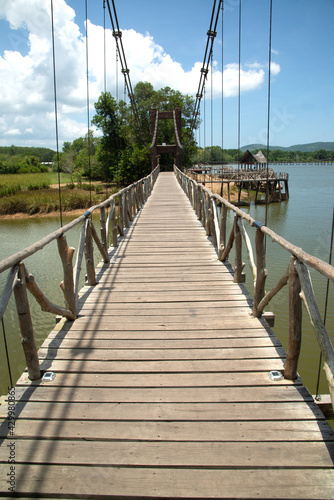 Wooden suspension bridge that crosses a reservoir in a public park in Thailand.