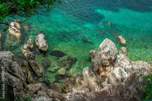 Beautiful landscape with sea bay with turquoise water  rocks and cliffs  green trees and bushes. Corfu Island  Greece.