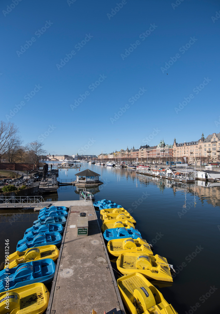 Spring view over pedaling boats at a jetty in Stockholm inner harbor