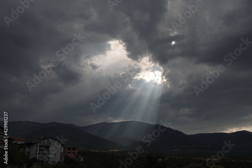 Sunbeams filtering across the cloudy sky