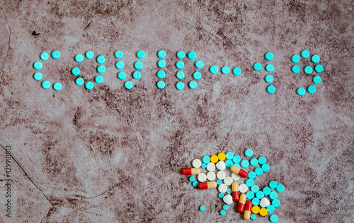 The pills arrange in word COVID 19 photo