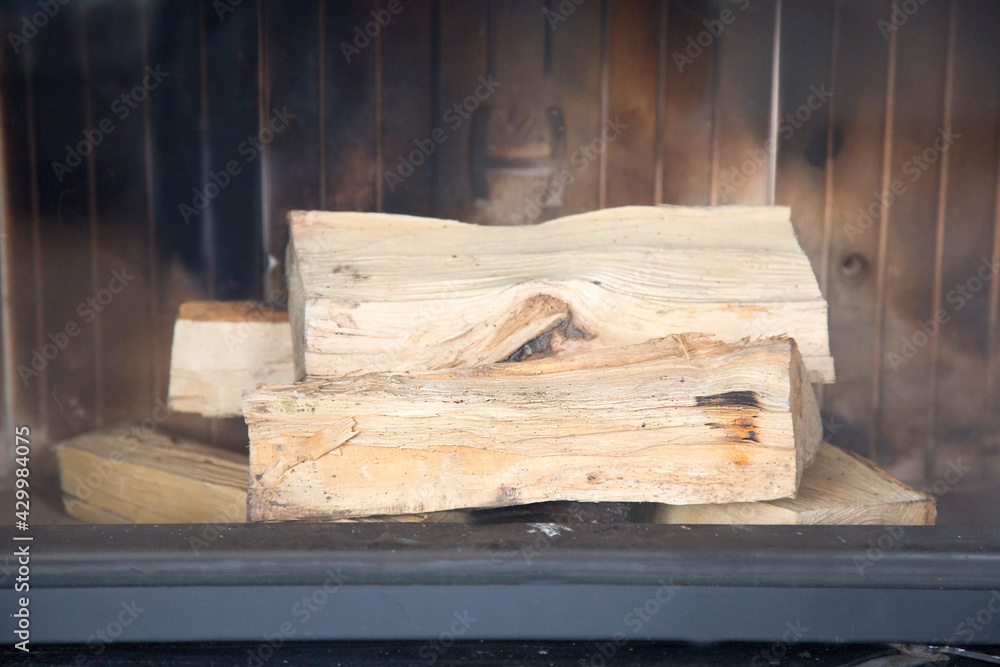 firewood in the non-burning fireplace in the gray interior of the living room. Ignition of the fireplace. Interior design, close up firewood in the non-burning fireplace in the gray interior of the living room. Ignition of the fireplace. Interior design, close up