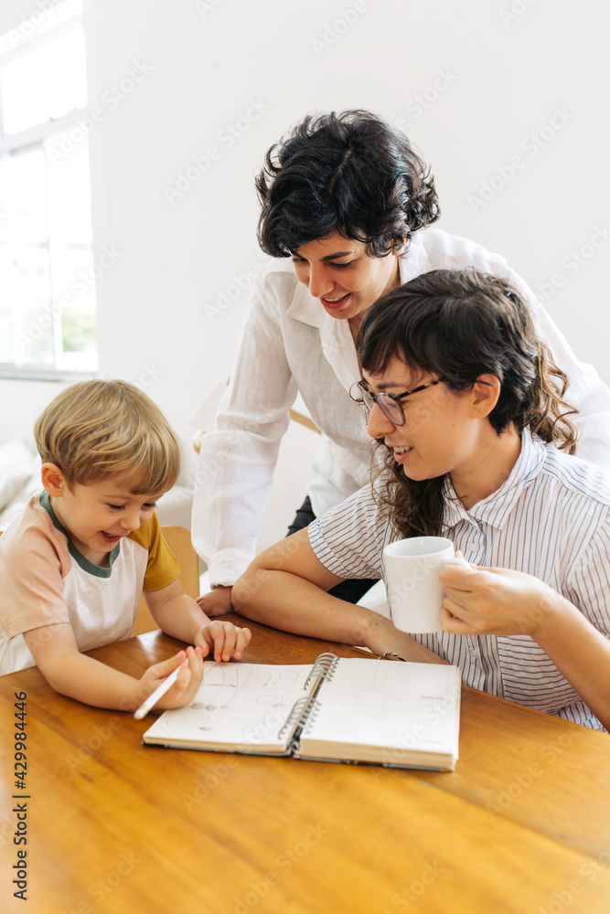 Boy having fun while studying with parents Boy having fun while studying with parents