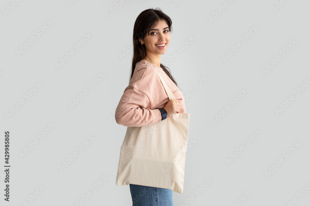 Portrait of young woman standing with blank canvas tote bag Portrait of young woman standing with blank canvas tote bag