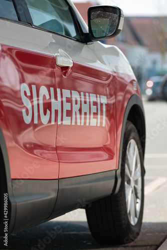 Aufnahme der rechten Seite  eines privaten weiss roten Fahrzeug mit der Aufschrift Sicherheit