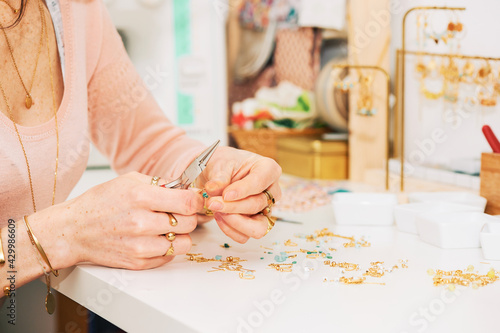 Close up image of female hands working with jewelry parts, woman making handcraft earrings