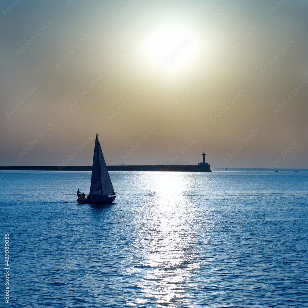 Sail boat on sunset sea sky