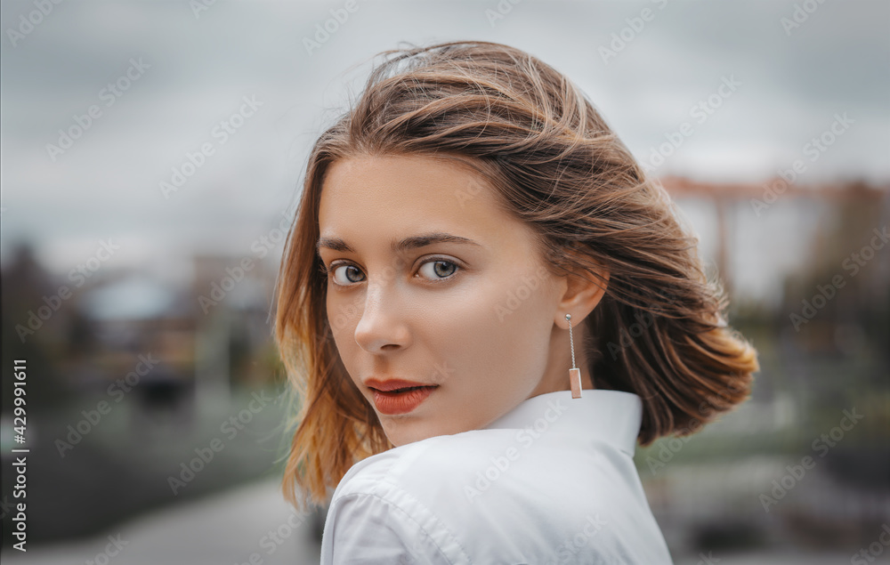 Close up portrait of a young woman in the city.