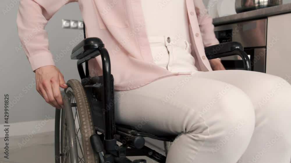 Young Handicapped Woman On Wheelchair Cleaning Stove Young Handicapped Woman On Wheelchair Cleaning Stove
