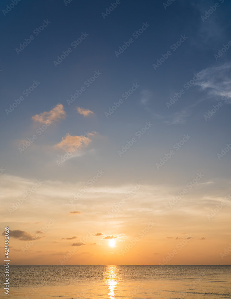 Obraz premium Sunset sky vertical over sea in the evening with colorful orange sunlight 