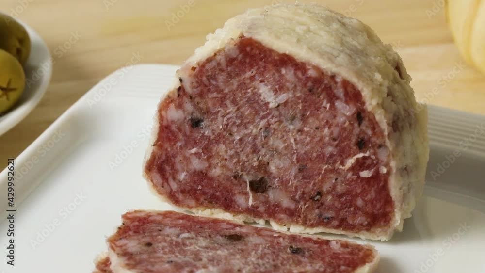 Saltufo sausage and slices on a dish close up Saltufo sausage and slices on a dish close up