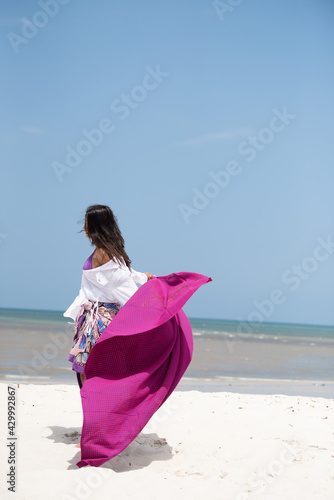 woman wearing white top posing on the beach