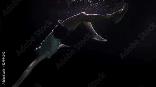 motionless and breathless female body is floating underwater, slow motion shot of sunken woman