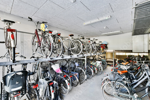 Schilderij op canvas Many bikes placed on rack and floor in storage room of contemporary apartment bu