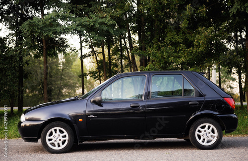 Photo Belarus, Minsk-October 12, 2019:Ford Fiesta black 2000 year, parked in a parking lot in the forest,side view