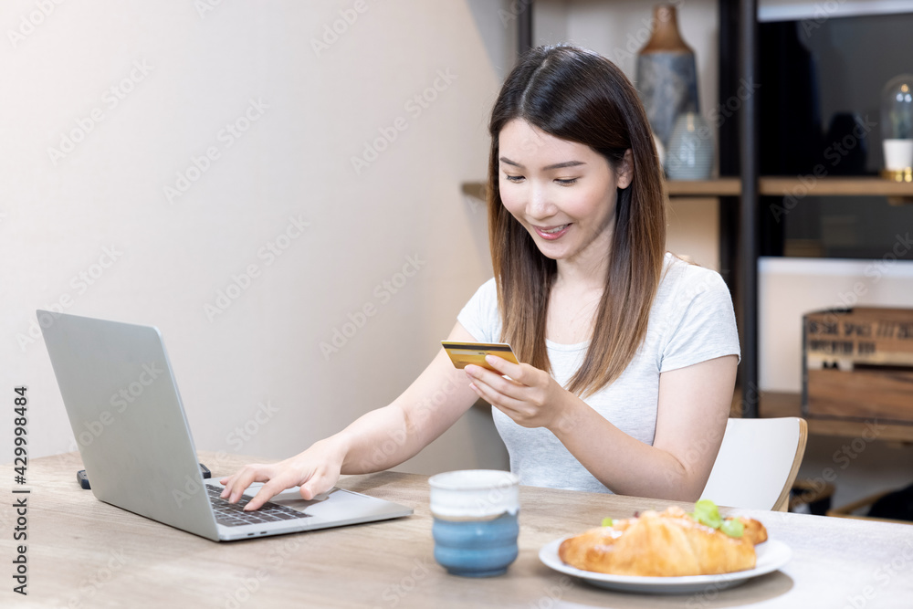 Asian woman use laptop computers to enter credit card information for online purchases. Asian woman use laptop computers to enter credit card information for online purchases.