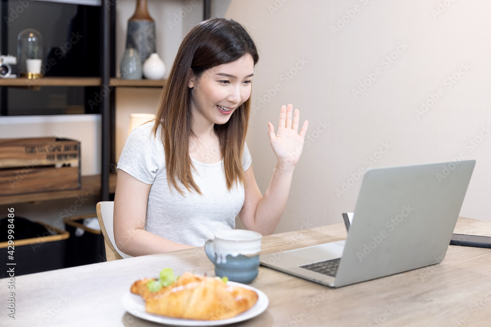 Asian woman speaks to her team of colleagues at an online video conference, Work from home.