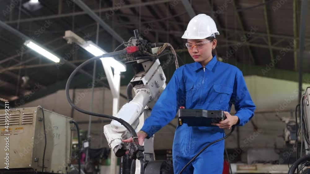 Engineer check and control welding robotics automatic arms machine in intelligent factory industrial. Engineer check and control welding robotics automatic arms machine in intelligent factory industrial.