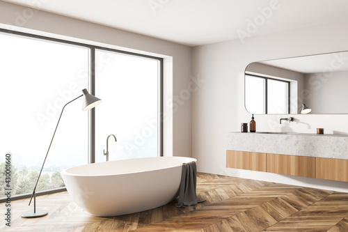 Bathroom interior with bathtub and sink with window on countryside