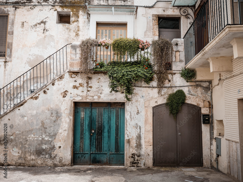 Old Italian building with old doors and plants, South of Italy, Puglia
