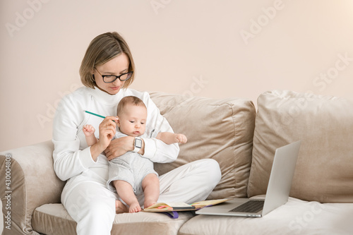 Work from home. Mother working with child and laptop computer at home. Quarantine and closed school during coronavirus outbreak.                   