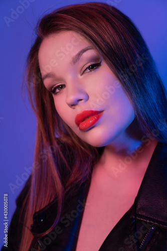 Portrait of a young girl with long hair  close-up. Photoshoot in neon light