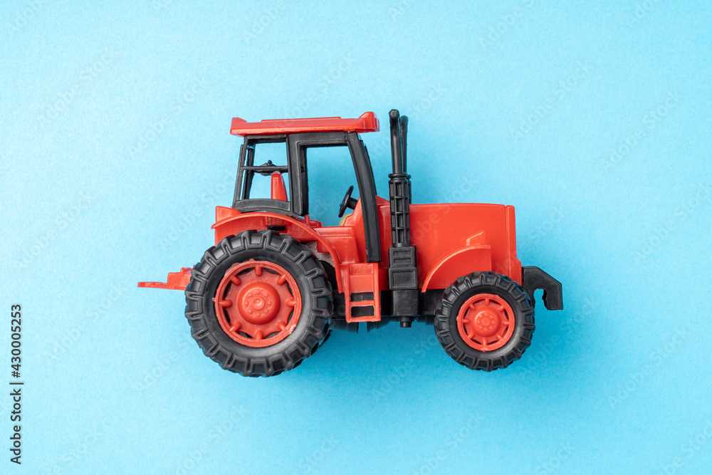 red toy tractor on a blue background, red toy tractor on a blue background,