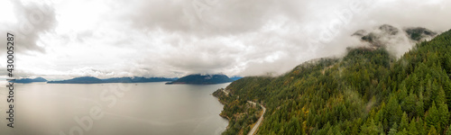 Aerial panoramic view of the Sea to Sky Highway in Howe Sound, North of Vancouver, British Columbia, Canada. Taken during a cloudy winter day.