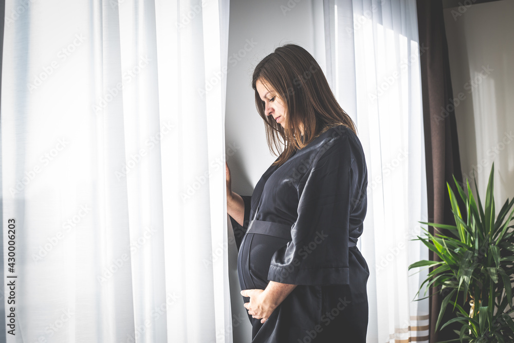 Young pregnant woman with a medical face mask during coronavirus pandemic, pregnancy during covid-2019 Young pregnant woman with a medical face mask during coronavirus pandemic, pregnancy during covid-2019