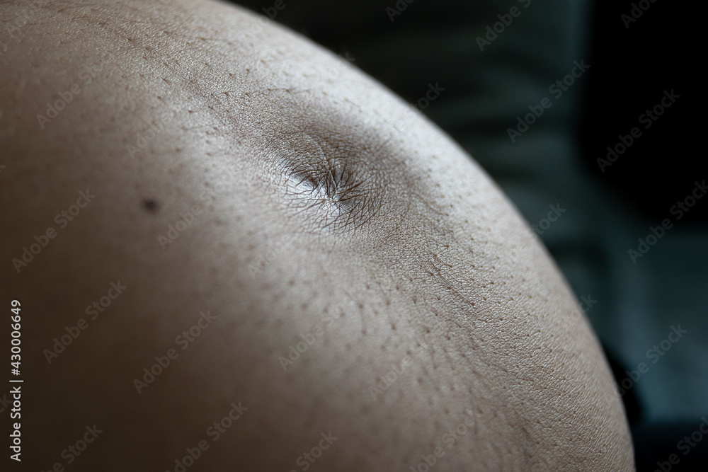 Fototapeta premium Close-up, from the side, of the belly button of a pregnant woman.