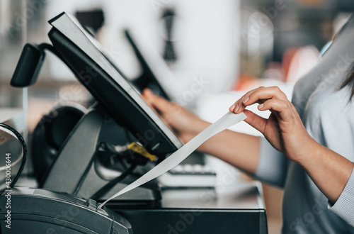 Photos saleswoman or shopgirl printing a receipt or invoice for a customer, sales time,