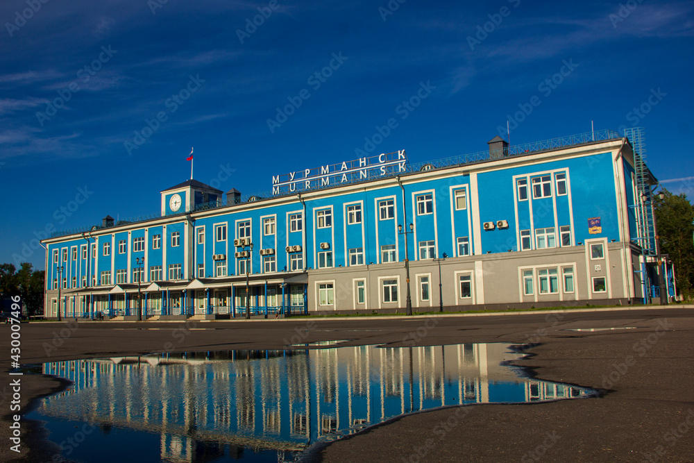 Fototapeta premium Marine Terminal in Murmansk and its reflection in a rain puddle, Russia, August 2020