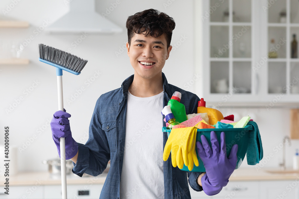 Excited asian guy ready for cleaning apartment Excited asian guy ready for cleaning apartment