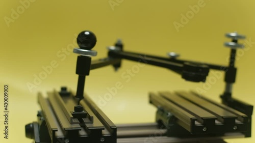 Engraving device pantograph rotating on yellow background photo