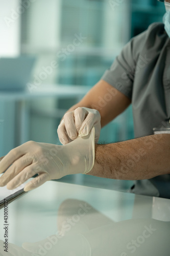 Medical researcher putting gloves on hands