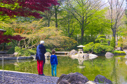 Grandmother and grandson watching the fishes in the lake. People in the park photo