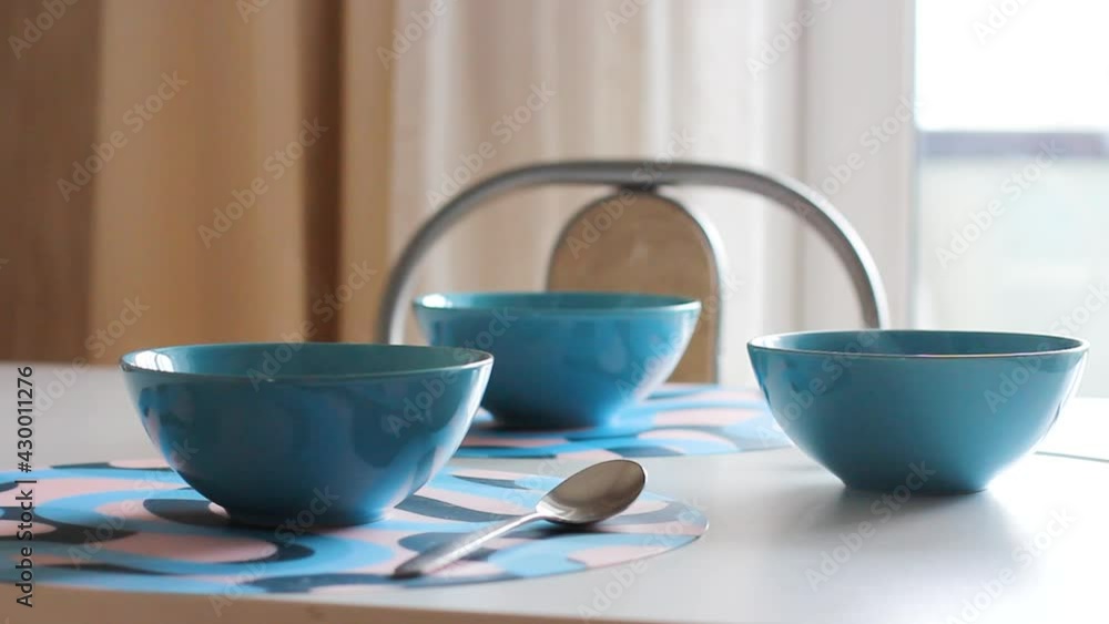 three blue plates on the table with hot porridge or soup that are steaming three blue plates on the table with hot porridge or soup that are steaming