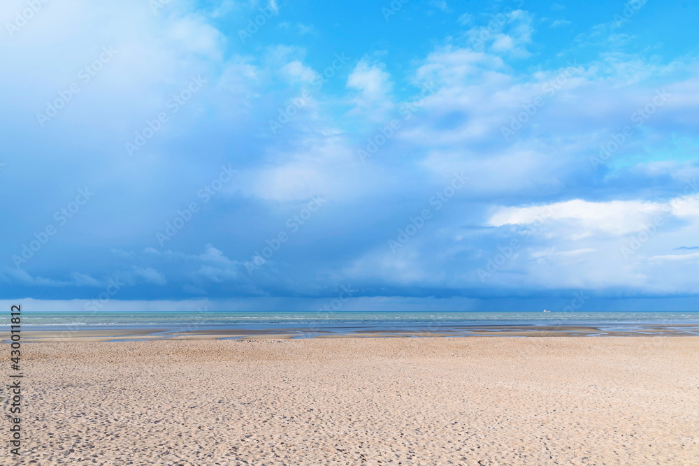 La plage de Sword beach à Ouistreham sous un ciel avec des nuages orageux en France, en Normandie, dans le Calvados, au bord de la Manche.