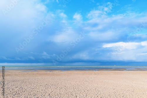 La plage de Sword beach à Ouistreham sous un ciel avec des nuages orageux en France, en Normandie, dans le Calvados, au bord de la Manche.