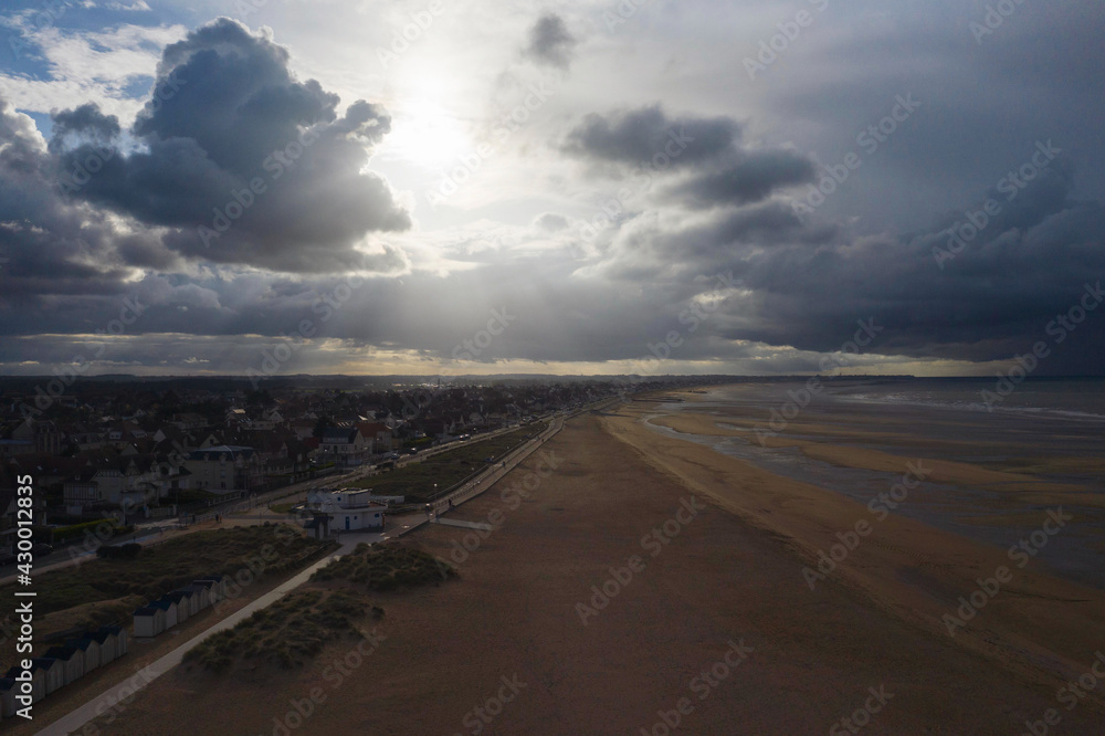 La plage de Sword beach à Ouistreham lors d'un orage au coucher du Soleil en France, en Normandie, dans le Calvados, au bord de la Manche.