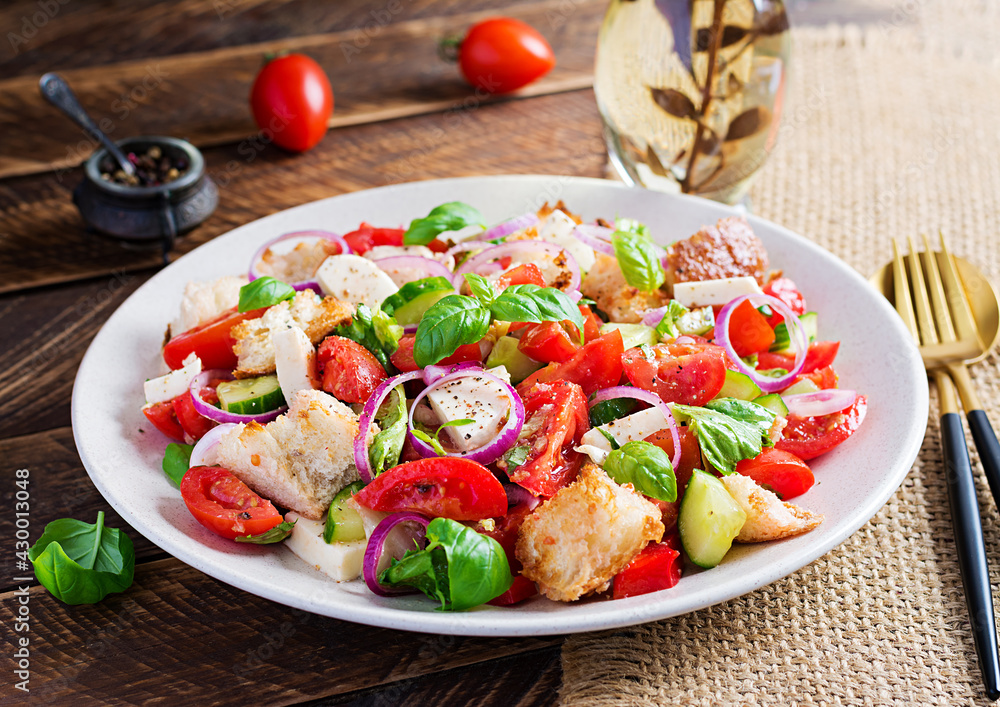 Tuscan Panzanella, traditional Italian salad with tomatoes and bread on wooden background. Vegetarian panzanella salad. Mediterranean healthy food. Tuscan Panzanella, traditional Italian salad with tomatoes and bread on wooden background. Vegetarian panzanella salad. Mediterranean healthy food.