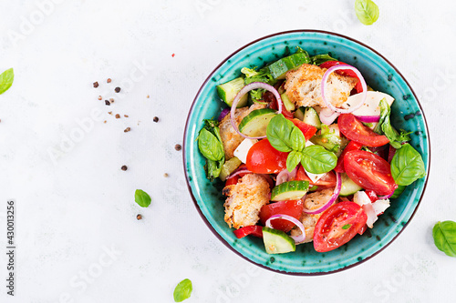 Traditional italian tomato salad panzanella with mozzarella, capers, red onion and croutons. Summer salad. Tuscan salad. Top view, above, copy space