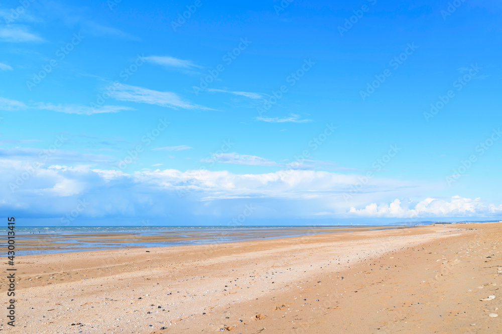 La plage de Sword beach à Ouistreham sous un ciel avec des nuages en France, en Normandie, dans le Calvados, au bord de la Manche. La plage de Sword beach à Ouistreham sous un ciel avec des nuages en France, en Normandie, dans le Calvados, au bord de la Manche.