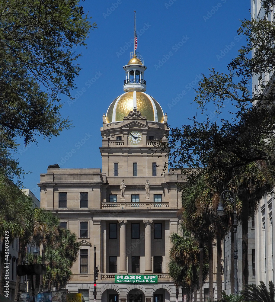 Beautiful downtown Savannah building with golden dome has a huge sign attached directing people to 