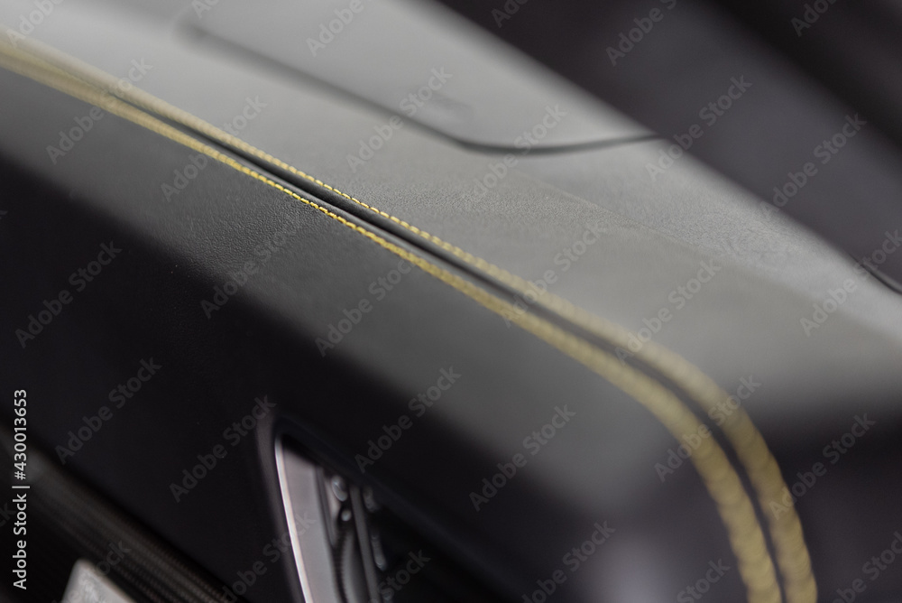 Fine details on this car interior dashboard with yellow stitching on a double row on the seam. Fine details on this car interior dashboard with yellow stitching on a double row on the seam.