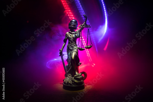 Law concept. Miniature colorful artwork decoration with fog and backlight. The Statue of Justice - lady justice or Iustitia Justitia the Roman goddess of Justice. Selective focus