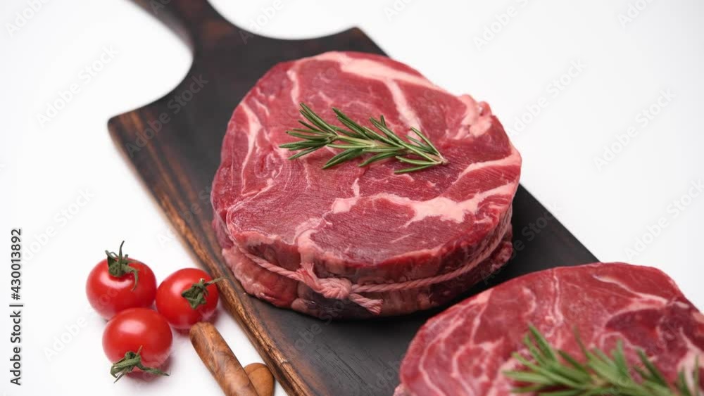 Fresh raw pieces of beef meat on a cutting board isolated on white background Fresh raw pieces of beef meat on a cutting board isolated on white background